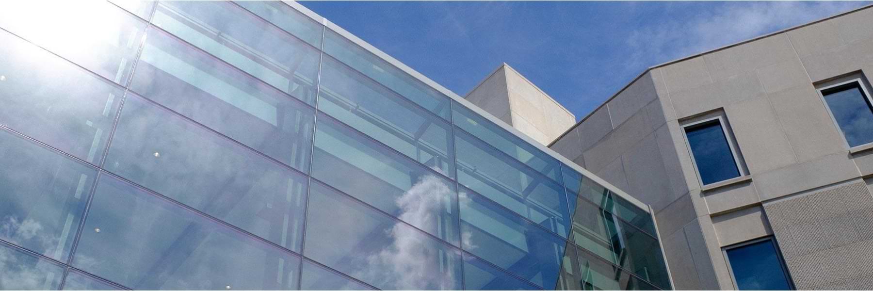 Clouds appear in the glass reflection of the Global and International Studies Building.